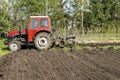 tractor machinery plowing agricultural field meadow at farm at spring autumn. Farmer cultivating and make soil tillage