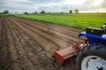 A tractor with a milling machine is cultivating a farm field. Loose crushed moist soil after cultivating with a cultivator Royalty Free Stock Photo