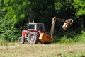 Tractor mounted hydraulic brush cutter at work in a summer day Royalty Free Stock Photo