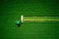 Tractor mowing agricultural green field, aerial drone view Royalty Free Stock Photo