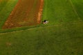 Tractor mowing pasture on big field of neatly cultivated land Royalty Free Stock Photo