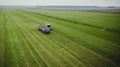Tractor mows the grass on a green field aerial view Royalty Free Stock Photo