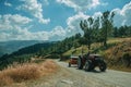 Tractor passing through roadway on hilly landscape Royalty Free Stock Photo