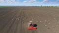 Tractor planting crops, aerial view, gulls and other birds flying around