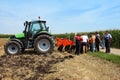 Tractor with plough on a presentation with farmers on the filed