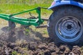 Tractor ploughs a field for sowing grain in spring, cultivating soil Royalty Free Stock Photo