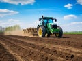 Tractor plowing field in early spring. farmer with tractor - sowing crops in agricultural field Royalty Free Stock Photo