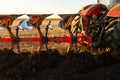 Tractor plowing field the land at sunset Royalty Free Stock Photo