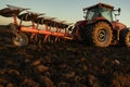 Tractor plowing field the land at sunset Royalty Free Stock Photo
