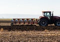 Tractor plowing field the land at sunset Royalty Free Stock Photo