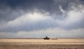 Tractor plowing a wheat field under a dramatic sky Royalty Free Stock Photo