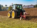 Tractor plows the field in the autumn