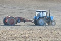 Tractor plows a field. Farmer in tractor preparing land with seedbed cultivator, sunset shot