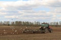 The tractor plows the field in the spring