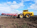 Tractor plows field. Tractor rides on the field and plows arable land. Details and close-up.