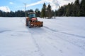 Tractor preparing slope on sunny winter day, Germany