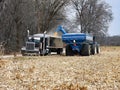 A tractor pulling a grain cart unloading corn into a semi truck grain hauler Royalty Free Stock Photo