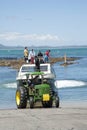 Tractor pulling trailer and dive boat from the ocean Royalty Free Stock Photo