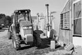 Tractor pulling a trailer type sprayer parks in front of green houses 2 Royalty Free Stock Photo