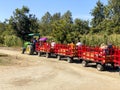 A tractor pulling a train of wagons on a seasonal adventures pumpkin patch festival.