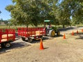 A tractor pulling a train of wagons on a seasonal adventures pumpkin patch festival.