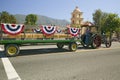 Tractor pulls decorated float down main street during a Fourth of July parade in Ojai, CA