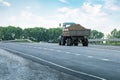 Tractor pulls trailer with potatoes driving on the road