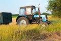 Tractor pulls up for loading to the combine with wheat