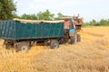 Tractor pulls up for loading to the combine with wheat