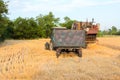 Tractor pulls up for loading to the combine with wheat