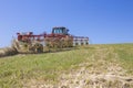 Tractor raking hay over sloped ground Royalty Free Stock Photo