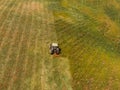 Tractor removes green grass from field, concept of harvesting silage and hay for cows. Aerial top view Royalty Free Stock Photo