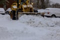 Tractor removing snow on street after snowfall Royalty Free Stock Photo