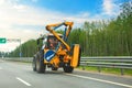 Tractor with road sign arrow detour and brush arrow crane for washing bumper or highway guardrail