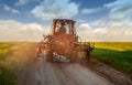 tractor on the road on the farm on sunset. Silhouette of old tractor in country road on the way to home Royalty Free Stock Photo