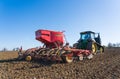 Tractor with seed drill sowing seeds in the Spring. Hertfordshire. UK