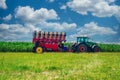 Tractor seeder in a green corn field. Bright summer agricultural view