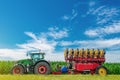 Tractor seeder in a green corn field. Bright summer agricultural view with machinery