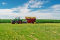 Tractor seeder in a green corn field. Bright summer agricultural view with machinery Royalty Free Stock Photo