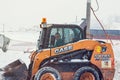 Tractor with snowplow removing snow during heavy snowfall