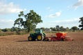 A tractor sows seed in a field.