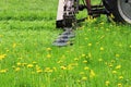 The tractor with a special nozzle automatically mows the grass on an urban lawn. Royalty Free Stock Photo