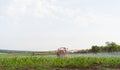 Tractor sprayer fertilizes field with insecticidal herbicides in agriculture on farm plantation. Soil cultivation in a Royalty Free Stock Photo