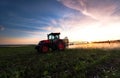 Tractor spraying a field on farm in spring.