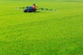 Tractor spraying glyphosate pesticides on a field