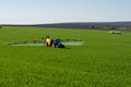 Tractor spraying pesticide in a field of wheat Royalty Free Stock Photo