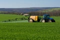 Tractor spraying pesticide in a field of wheat Royalty Free Stock Photo