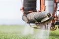 Tractor spraying pesticide on wheat field with sprayer