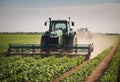 Tractor spraying pesticides on plant field with sprayer at spring. Organic farm and agriculture. Generative Ai Royalty Free Stock Photo