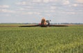 Tractor spraying pesticides wheat field Royalty Free Stock Photo